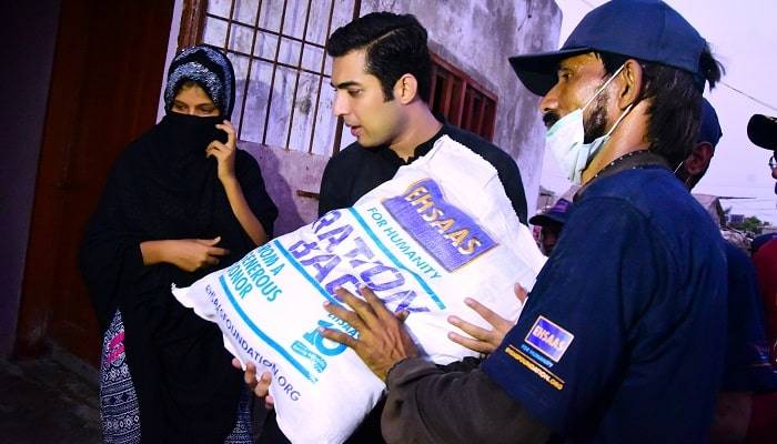 Syed Iqrar ul Hassan distributing Rations to flood victims