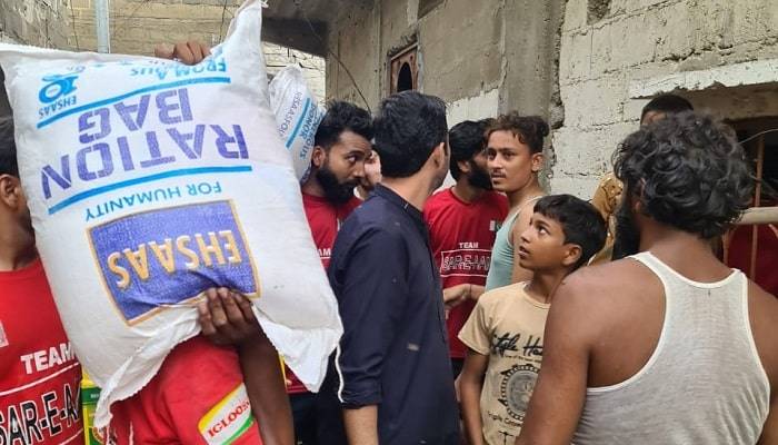 Syed Iqrar ul Hassan distributing Rations to flood victims